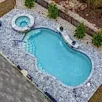 Lux Project 14 custom oasis pool with integrated spa, surrounded by waterfalls and a fireplace